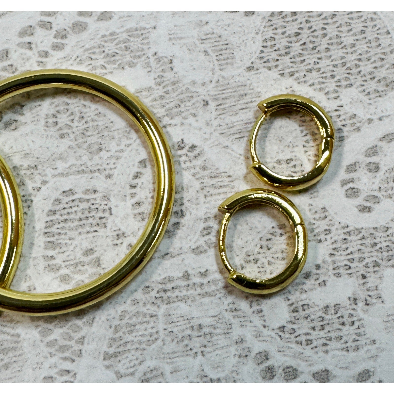 A Pair of Gold Hoop Earrings  One 1 1/4 Inch and One Huggies 3/8 Inch E299